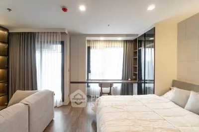 Spacious modern bedroom with large windows and elegant decor, perfect for comfort and relaxation.