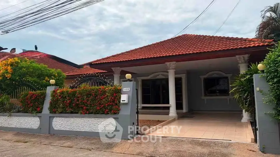 Charming single-story home with red-tiled roof and lush garden in a serene neighborhood.