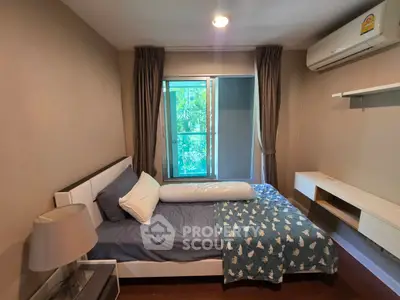 Cozy bedroom with modern furnishings and large window overlooking greenery.