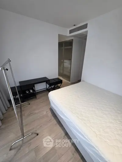 Modern minimalist bedroom with sleek flooring and ample natural light.