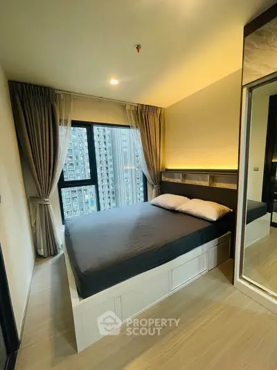 Modern bedroom with city view, featuring sleek design and ample natural light.