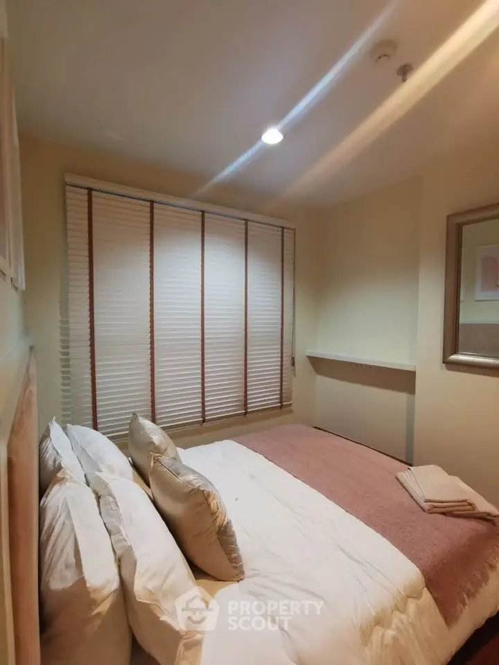 Cozy bedroom with soft lighting and plush bedding in modern apartment