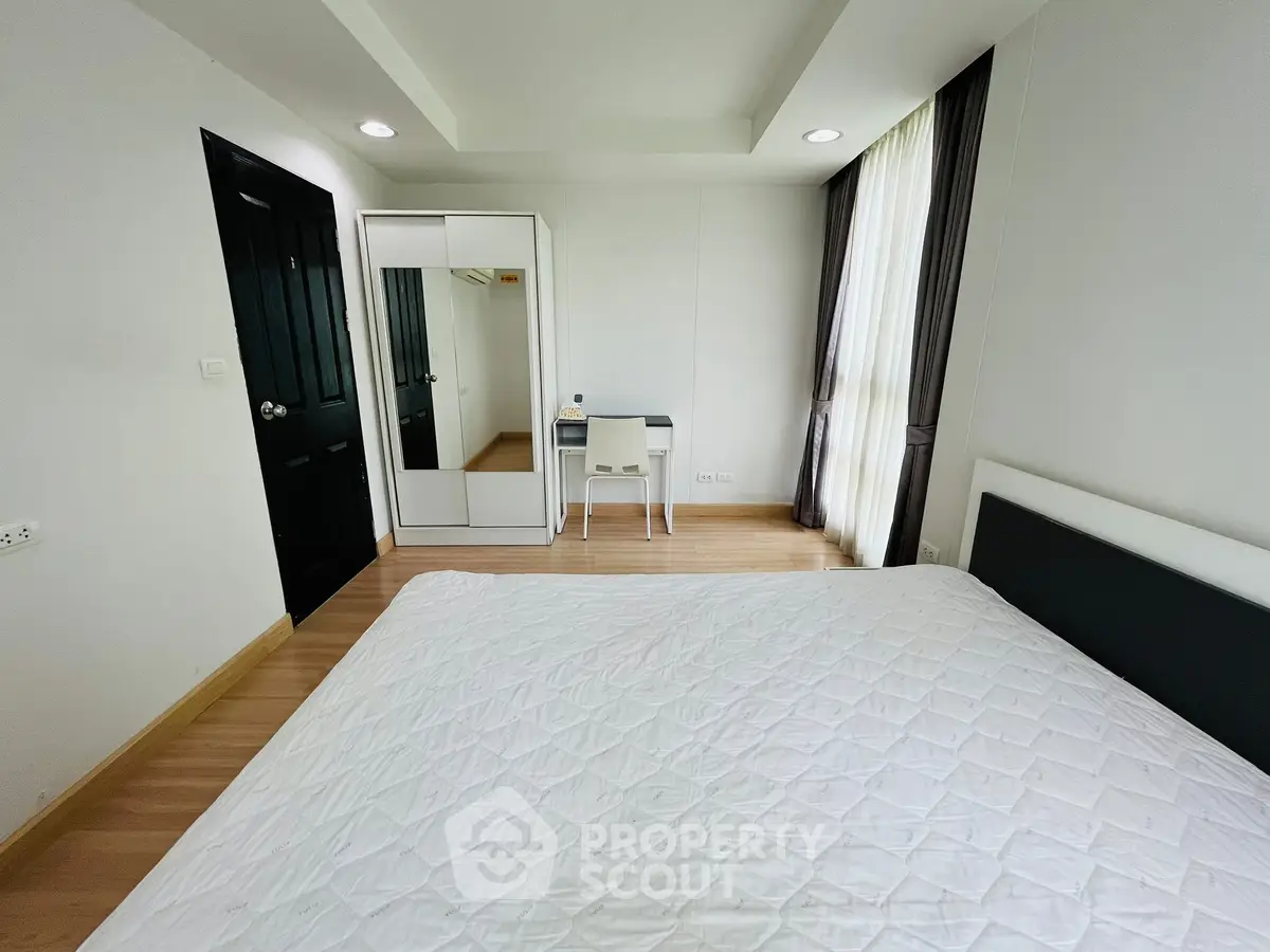 Bright and airy bedroom with modern furnishings and large window for natural light.