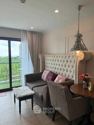 Charming living room with plush seating and balcony view in modern apartment.