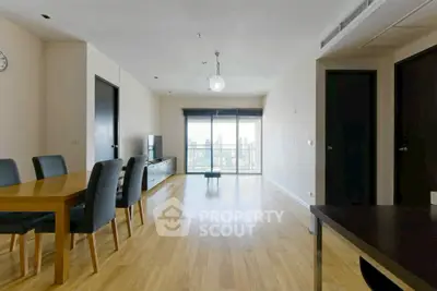 Spacious modern living room with wooden flooring and city view balcony.
