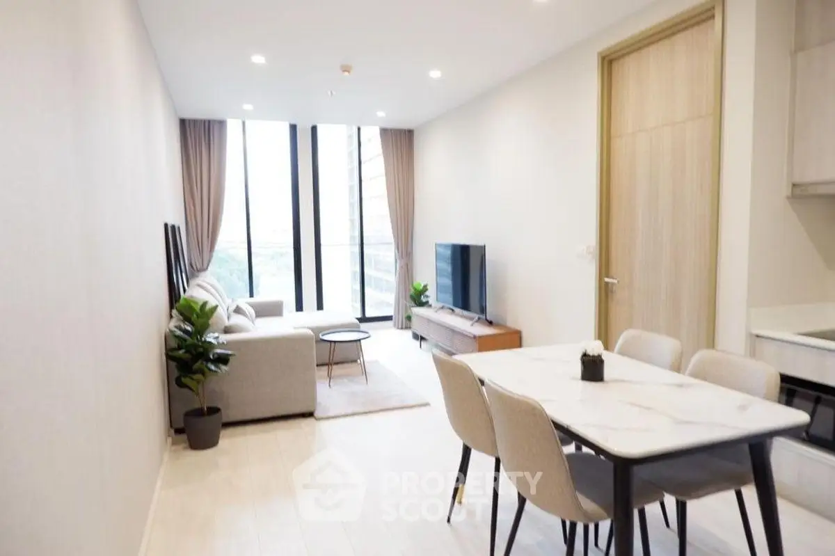 Modern living room with dining area and large windows in a stylish apartment.