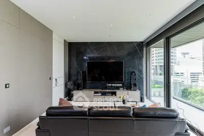Luxurious living room with sleek black marble wall, modern entertainment system, and plush leather sofa, complemented by natural light from large windows.