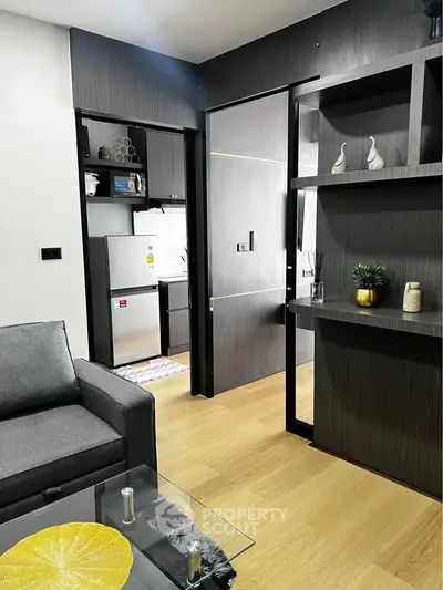 Modern living room with sleek furniture and open kitchen layout in a stylish apartment.