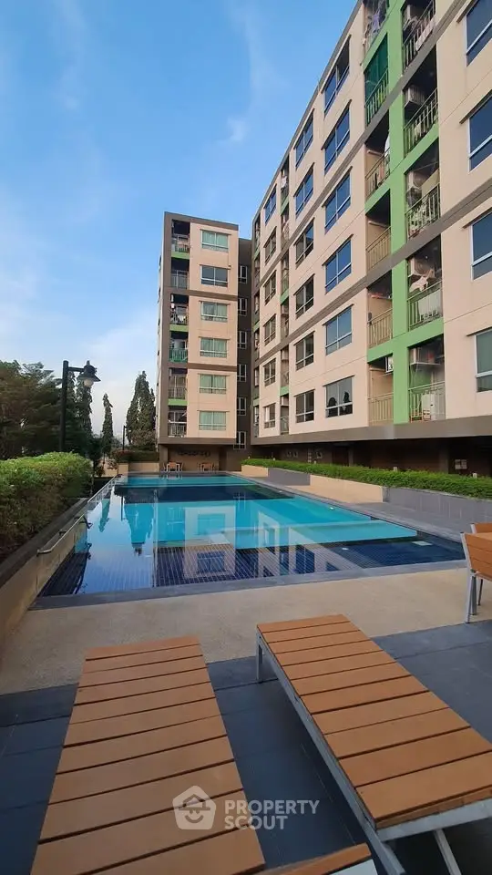 Modern apartment building with outdoor pool and lounge chairs