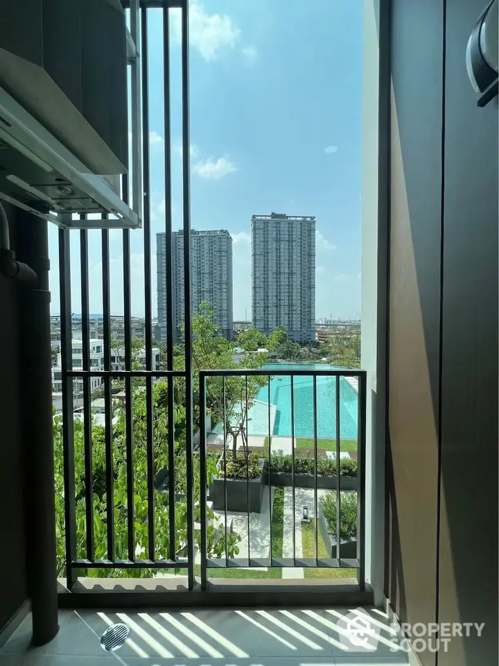 Stunning balcony view overlooking modern high-rise buildings and a sparkling pool.