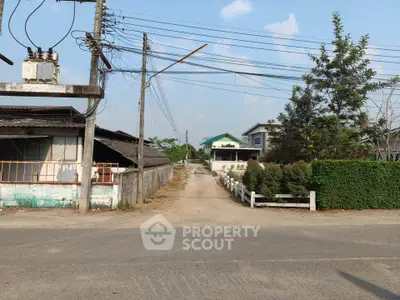 Charming rural property with spacious driveway and lush greenery, perfect for serene living.