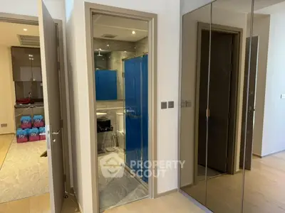 Modern bathroom with sleek design and mirrored closet doors in a stylish apartment.
