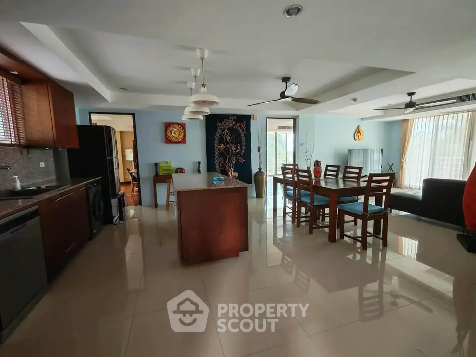 Spacious open-plan living and dining area with modern kitchen in a stylish apartment.