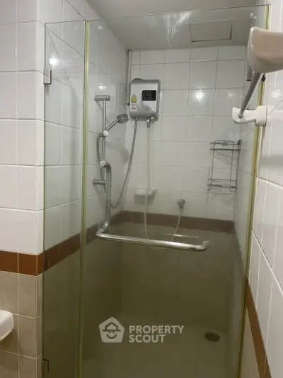 Compact bathroom shower with glass door and modern fixtures