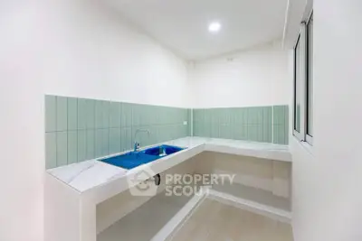 Modern minimalist kitchen with sleek countertops and green tile backsplash