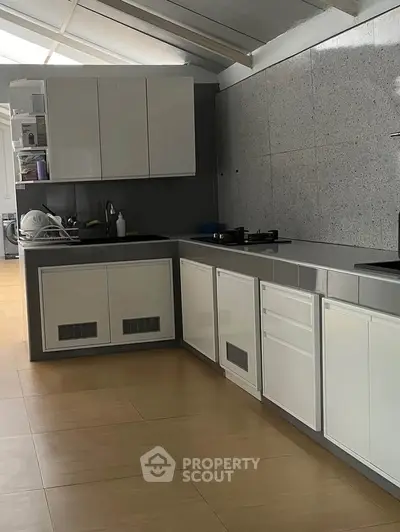 Modern kitchen with sleek cabinetry and gas stove in a spacious layout