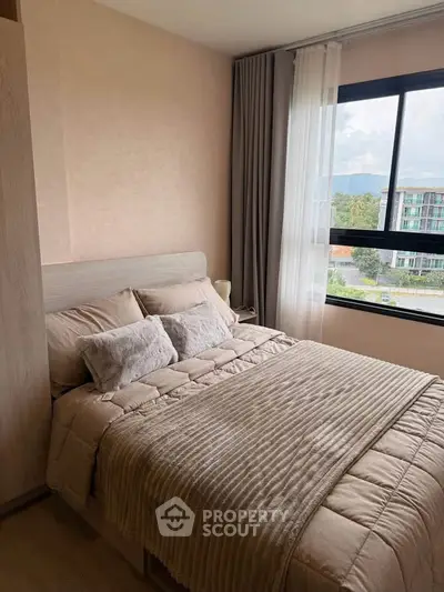 Cozy bedroom with plush bedding and large window offering scenic views in modern apartment.