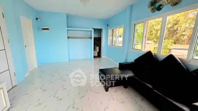 Spacious living room with modern decor and large windows offering natural light.