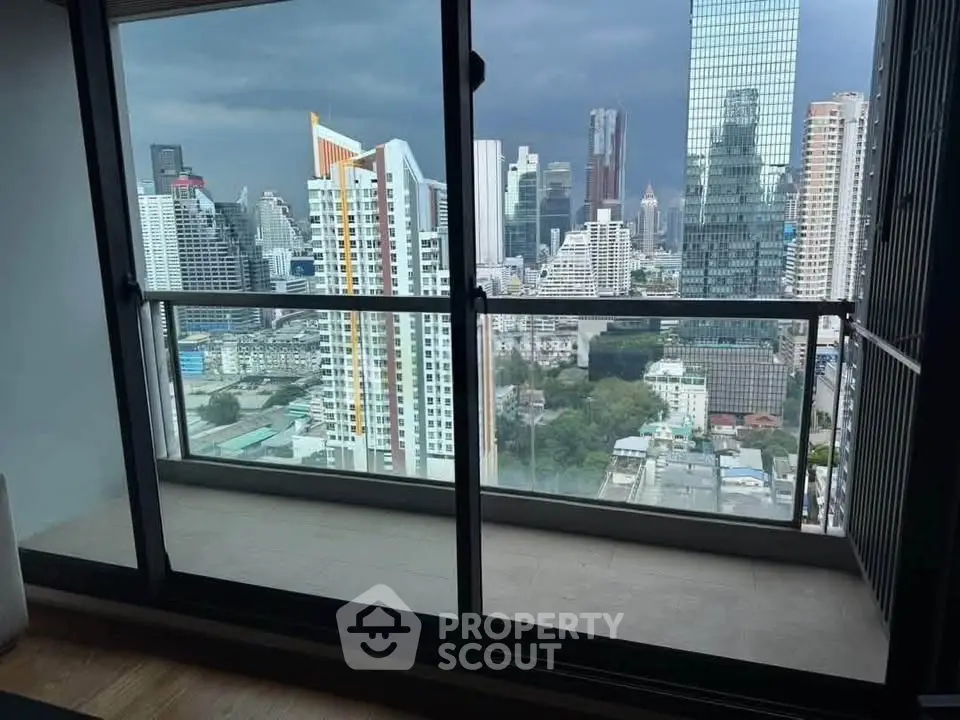 Stunning cityscape view from modern high-rise balcony with glass railing.