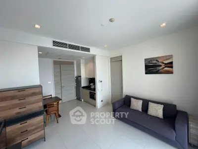 Modern living room with sleek furniture and integrated kitchen in a stylish apartment.