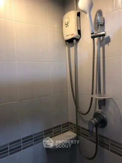 Modern bathroom with sleek shower and water heater installation.