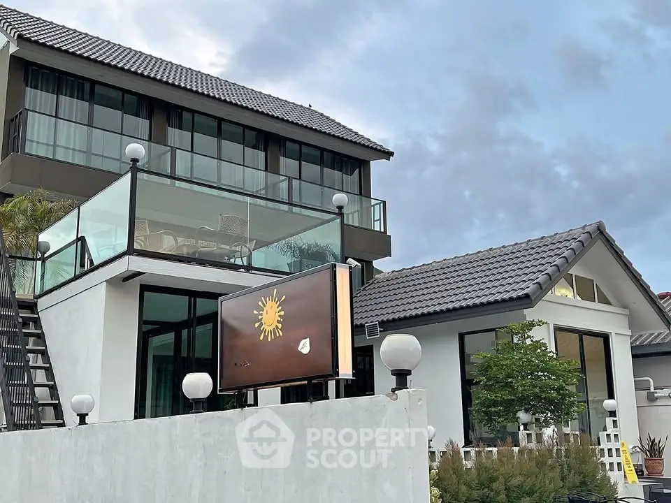 Modern multi-story house with glass balcony and stylish exterior design