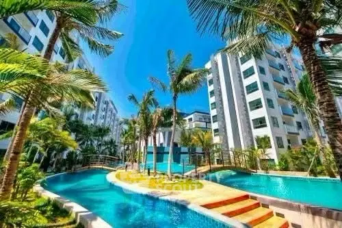 Luxurious residential complex with stunning pool and lush palm trees