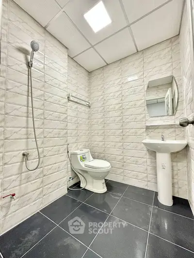 Modern bathroom with sleek tiles and minimalist fixtures.