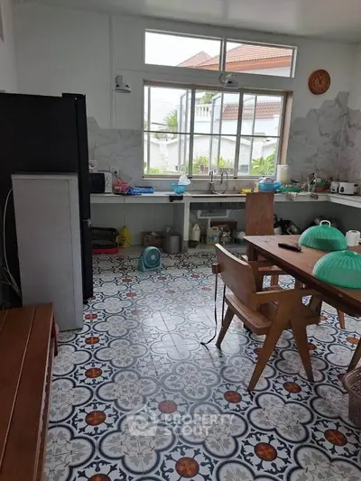 Charming kitchen with vibrant patterned tiles and wooden dining set, offering a cozy and inviting atmosphere.