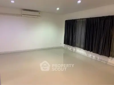 Spacious empty room with air conditioning and large windows, perfect for customization.