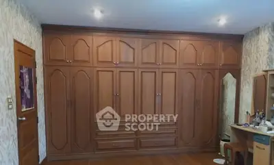 Spacious bedroom with elegant wooden built-in wardrobes and vanity area