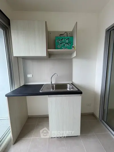 Modern compact kitchen with sleek cabinetry and stainless steel sink, perfect for urban living.