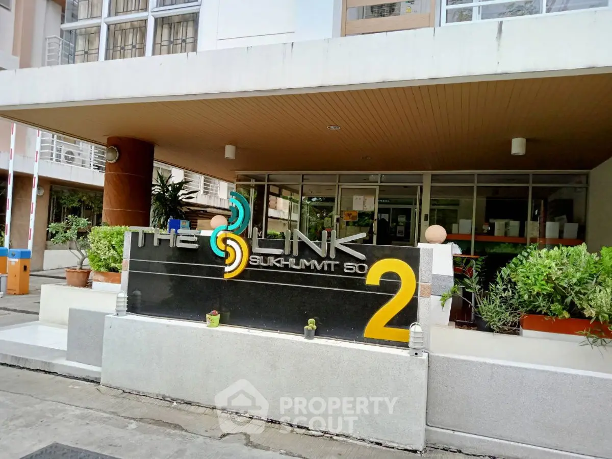 Stylish entrance of The Link Sukhumvit 50 with modern signage and lush greenery.
