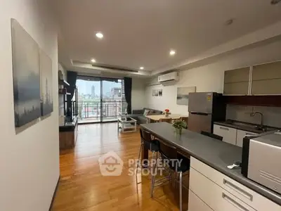 Spacious open-plan living room with modern kitchen and balcony view