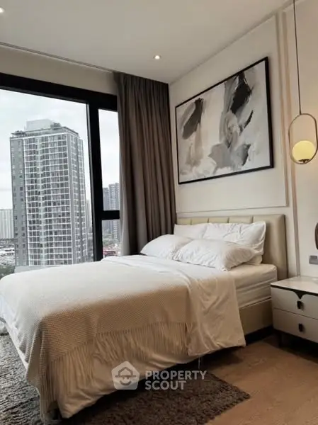 Modern bedroom with city view and stylish decor in high-rise apartment.