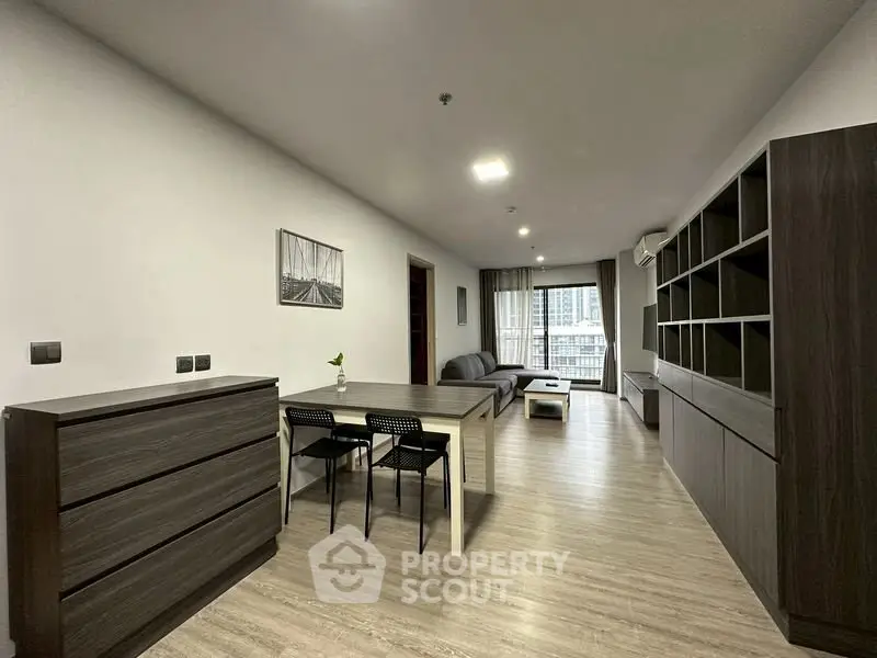 Spacious modern living room with sleek furniture and large windows offering city views.