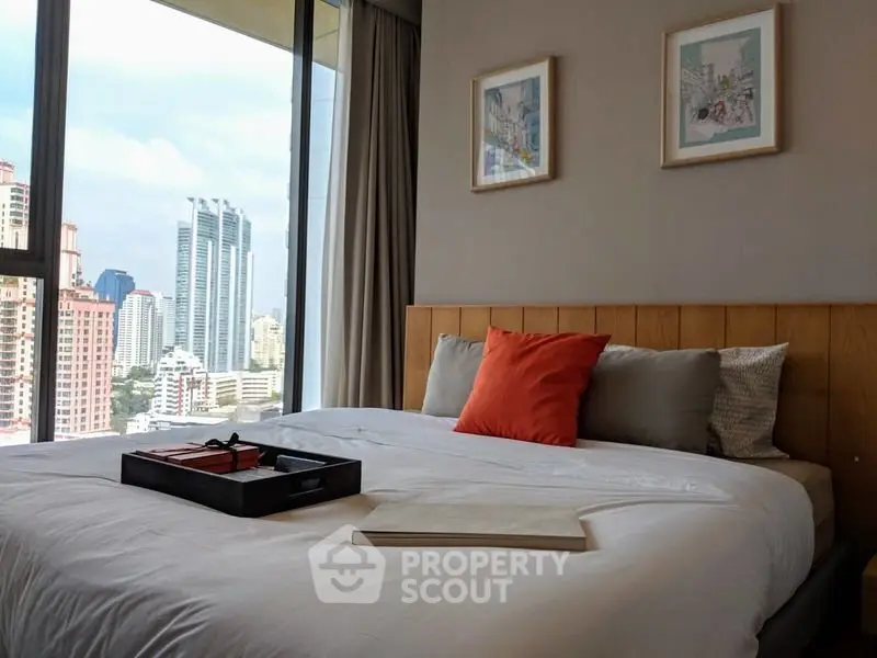 Luxurious bedroom with city view, elegant decor, and cozy bedding in modern apartment.