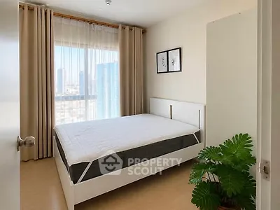 Bright bedroom with city view, modern decor, and large window for natural light.
