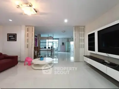 Spacious modern living room with sleek entertainment center and elegant lighting