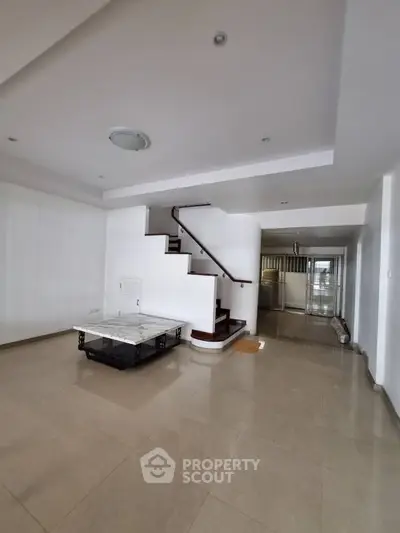 Spacious interior with modern staircase and open layout, ideal for stylish living.