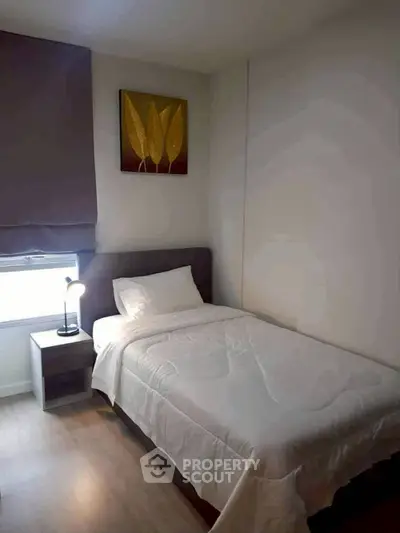 Cozy bedroom with single bed, modern decor, and natural light.