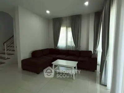 Spacious living room with modern sectional sofa and elegant curtains