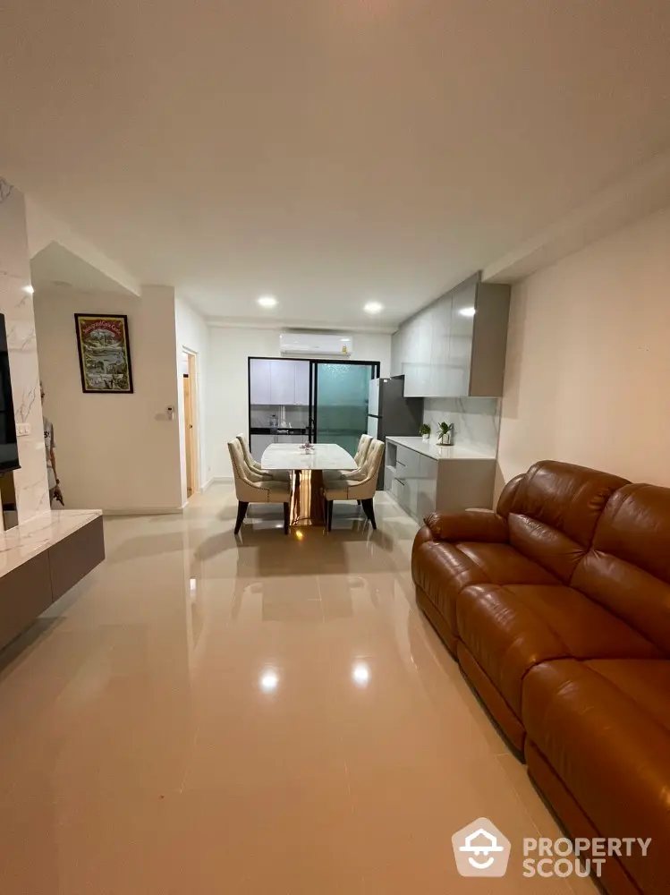 Spacious modern living room with leather sofa and dining area