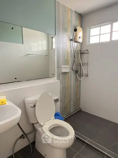 Modern bathroom with shower, toilet, and stylish wall tiles in a bright, airy space.