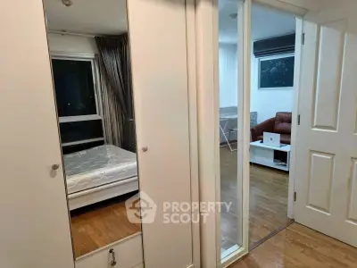 Modern apartment interior with bedroom and living room featuring wooden floors and stylish furniture.