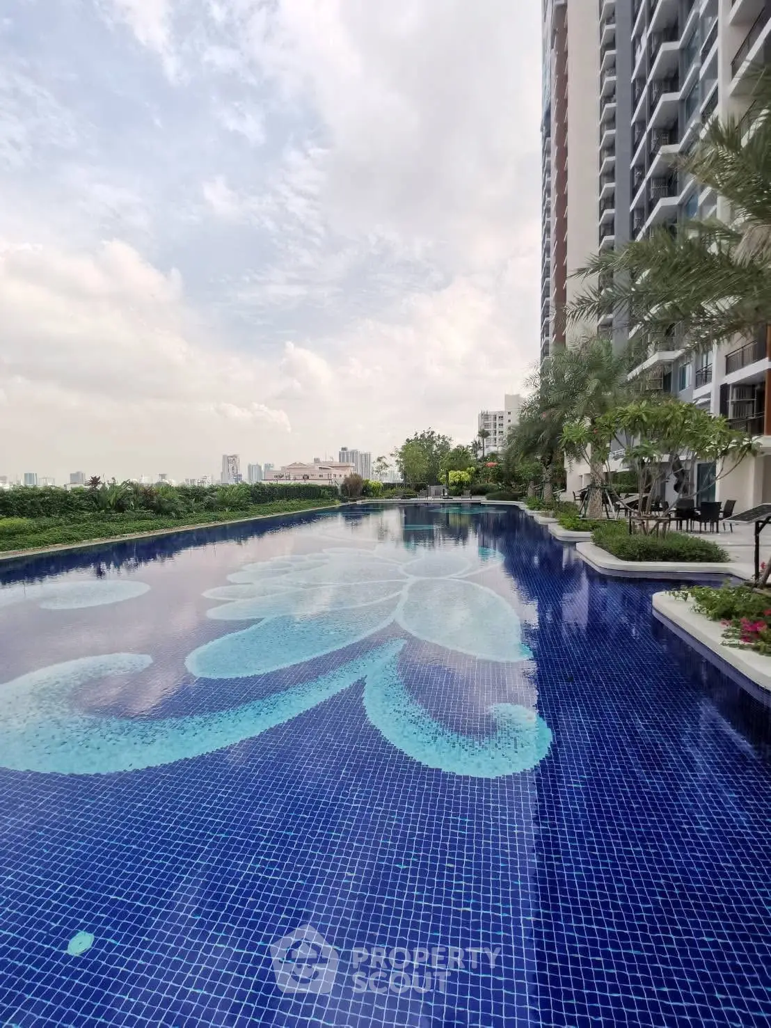 Luxurious residential pool with stunning cityscape view and modern high-rise building.