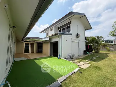 Spacious two-story house with lush green lawn and modern exterior design, perfect for family living.
