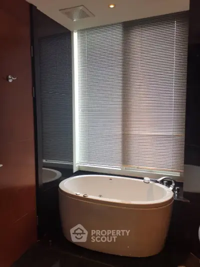 Luxurious bathroom with modern bathtub and sleek blinds