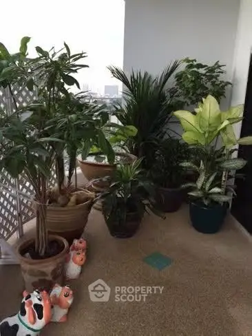 Charming balcony with lush potted plants and city view, perfect for relaxation.