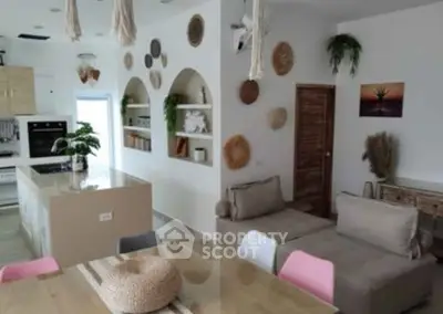 Stylish open-plan living room and kitchen with modern decor and natural accents.